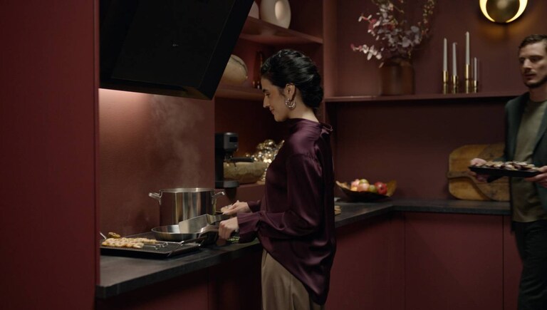 Woman and a man preparing food in a modern kitchen.