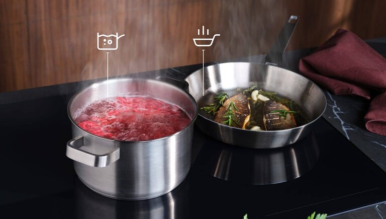 Food is being prepared on an induction hob with the SenseBoil and Fry function.