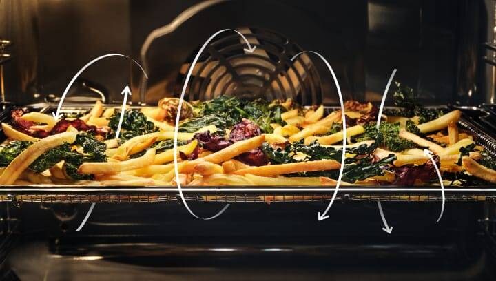 French fries and vegetables being prepared in an oven.