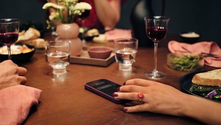 People sitting around a table with food and drink. 